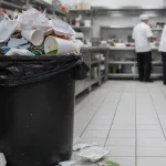 ظروف یکبار مصرف فومی درون سطل زباله یک آشپزخانه صنعتی